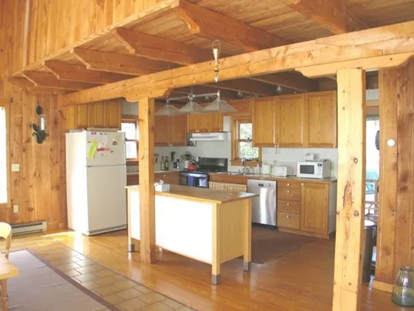 a kitchen with stainless steel appliances wooden floor and a refrigerator