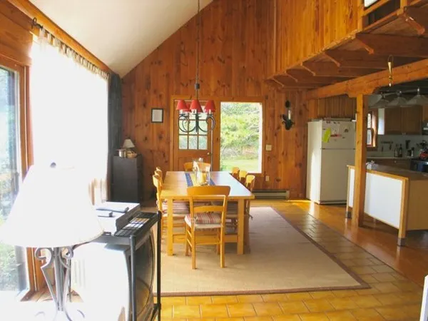 a dining room with furniture a chandelier and wooden floor