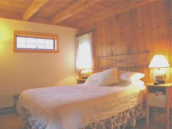 a bedroom with a bed and a lamp