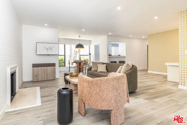 a living room with furniture a large window and wooden floor