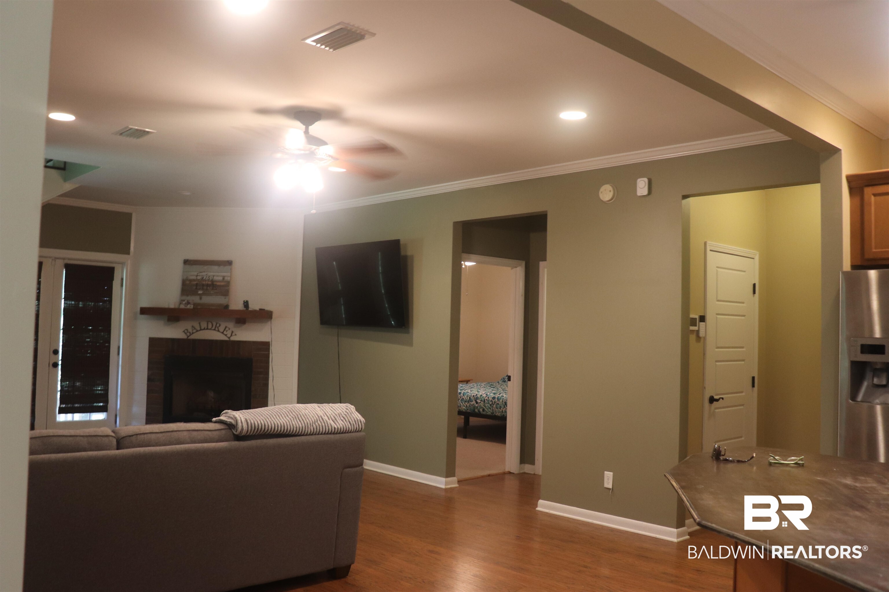 102 Brown Road Evergreen, AL 36401 - Photo 5 of 26 Living room with a ceiling fan, dark wood finished floors, a brick fireplace, crown molding, and recessed lighting