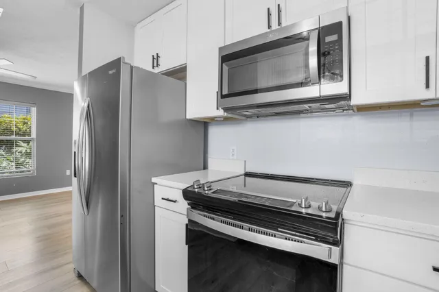 a kitchen with stainless steel appliances a stove microwave and refrigerator