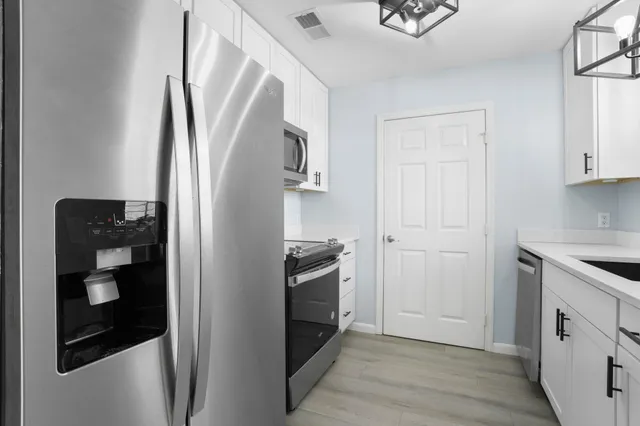 a kitchen with a refrigerator and a stove top oven