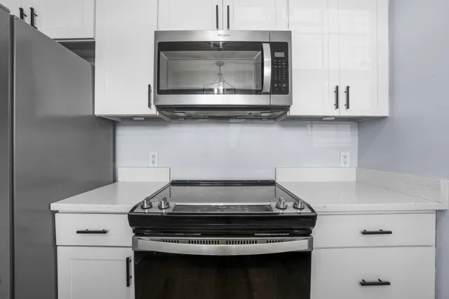 a stove top oven sitting inside of a kitchen