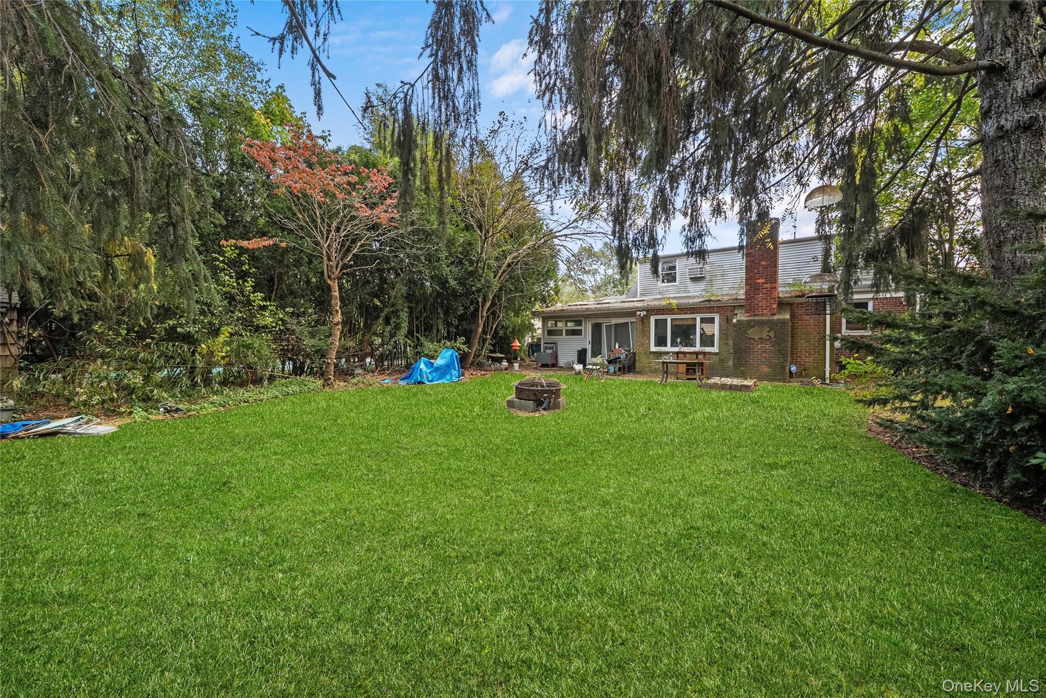 9 Tudor Road Farmingdale, NY 11735 - Photo 5 of 12 a view of a house with a big yard and large trees