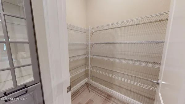 a view of a room with wooden floor chandelier and windows