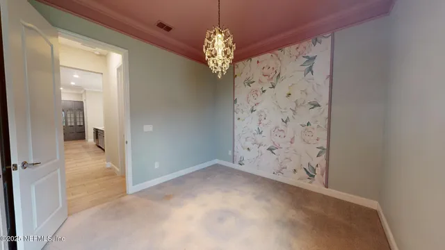 a view of a hallway with windows and chandelier