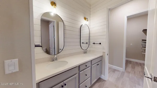 a bathroom with a double vanity sink mirror and shower