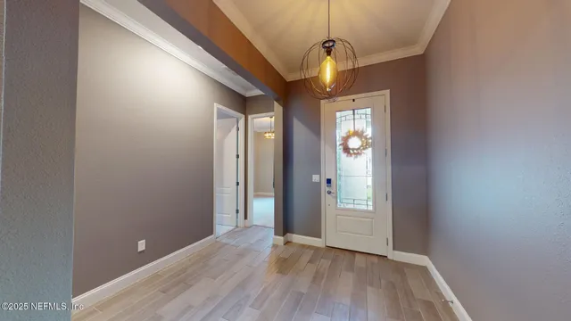 a view of a hallway with wooden floor and a chandelier