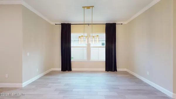 an empty room with a window and a ceiling fan