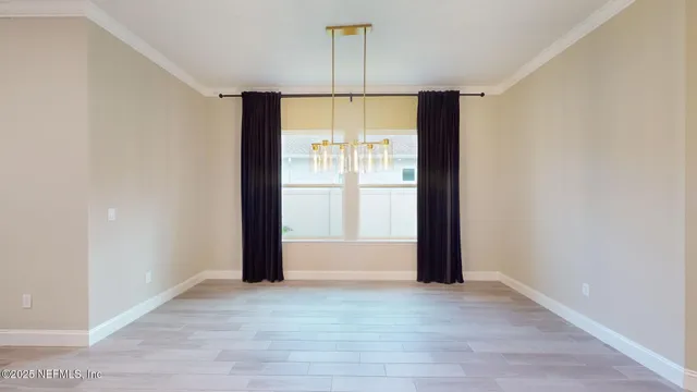 an empty room with a window and a ceiling fan