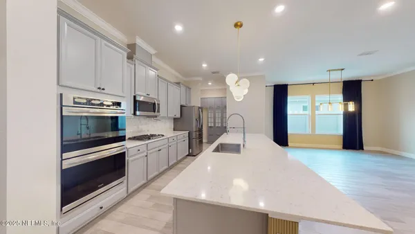 a kitchen with stainless steel appliances granite countertop a refrigerator and a stove top oven