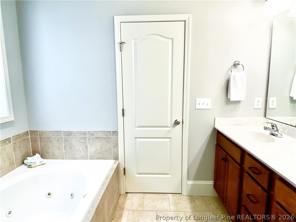 175 Pine Hawk Drive Spring Lake, NC 28390 - Photo 18 of 43 a bathroom with a tub sink and a mirror
