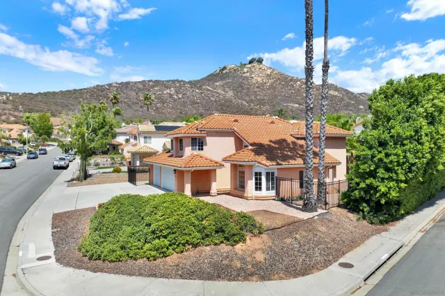 a front view of a house with a yard and mountain view