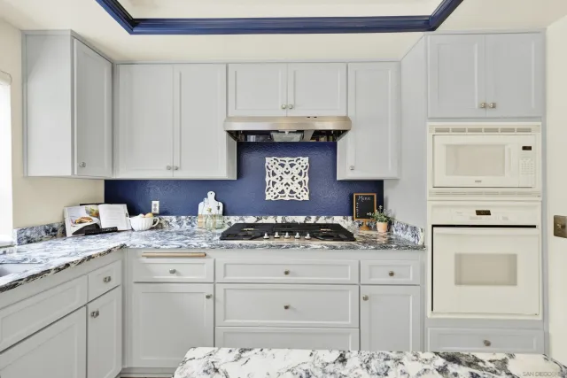 a kitchen with stainless steel appliances kitchen island granite countertop a stove refrigerator and cabinets