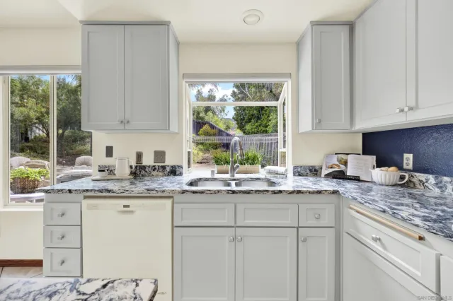 a kitchen with a white cabinets and chairs