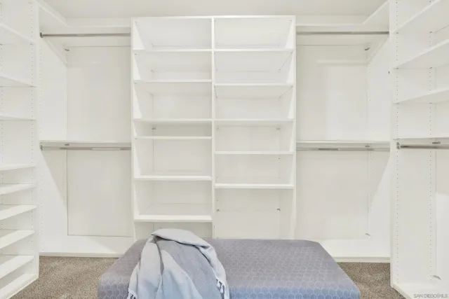 a view of walk in closet with clothes