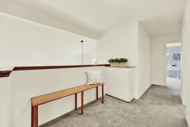 a view of a patio with a table and chairs and a floor to ceiling window and wooden fence