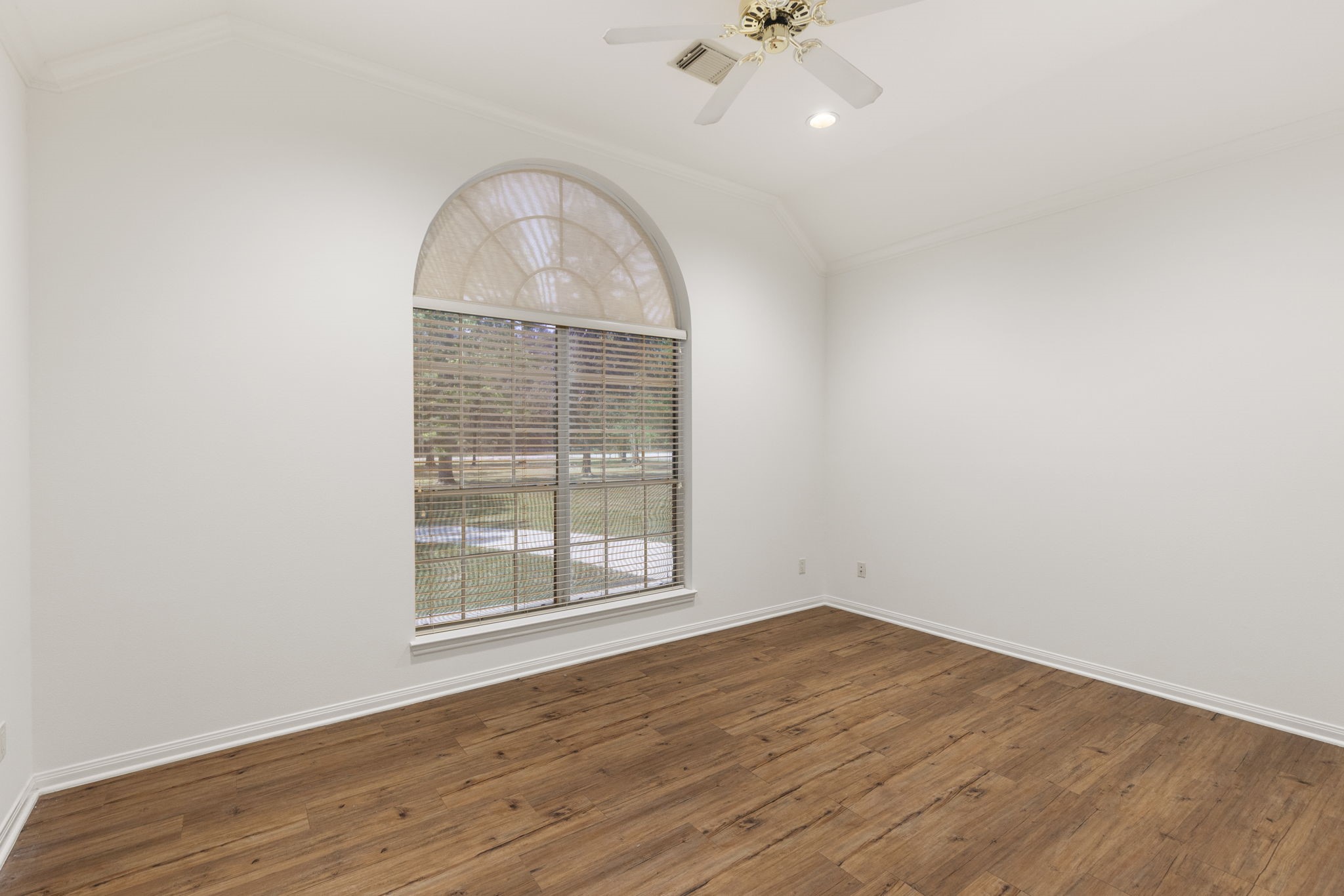 11534 Clint Parker Road Conroe, TX 77303 - Photo 12 of 50 an empty room with wooden floor chandelier fan and window