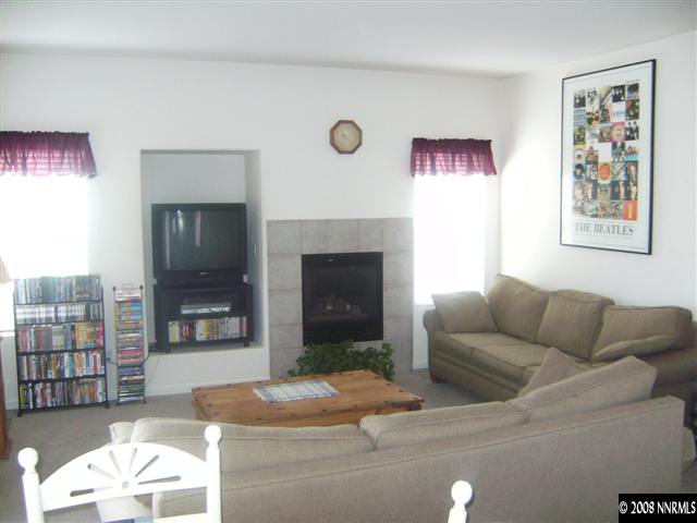 1665 Legacy Village Road Reno, NV 89521 - Photo 4 of 9 a living room with furniture a flat screen tv and a fireplace