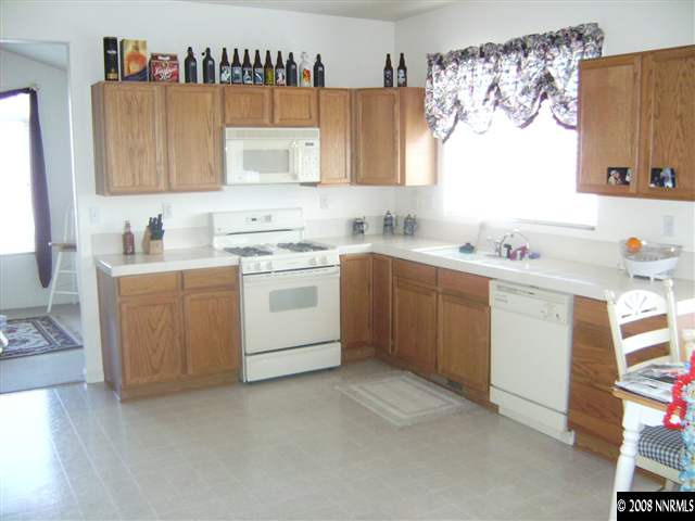1665 Legacy Village Road Reno, NV 89521 - Photo 5 of 9 a kitchen with a sink stove and cabinets