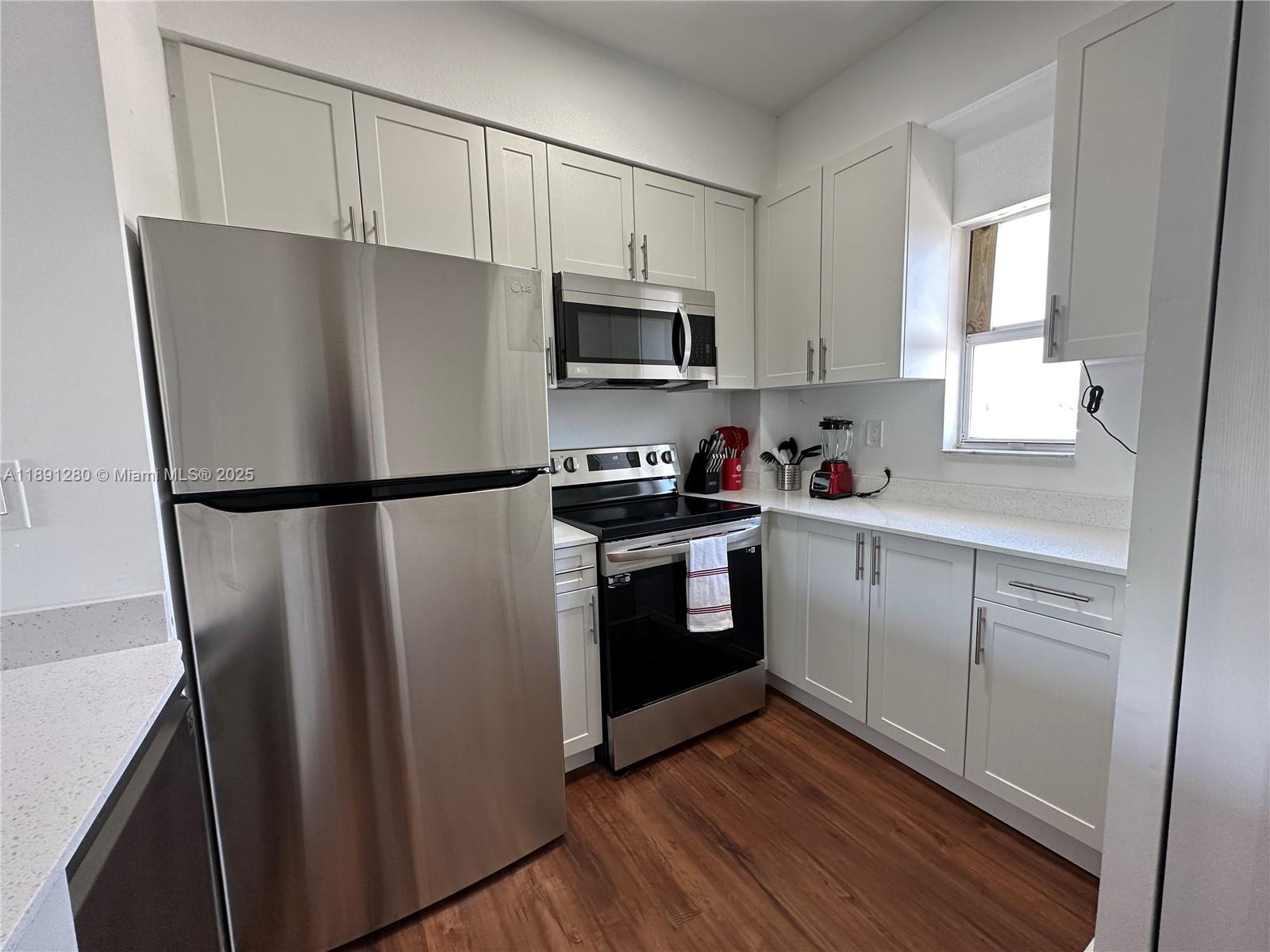 a kitchen with a refrigerator sink and cabinets