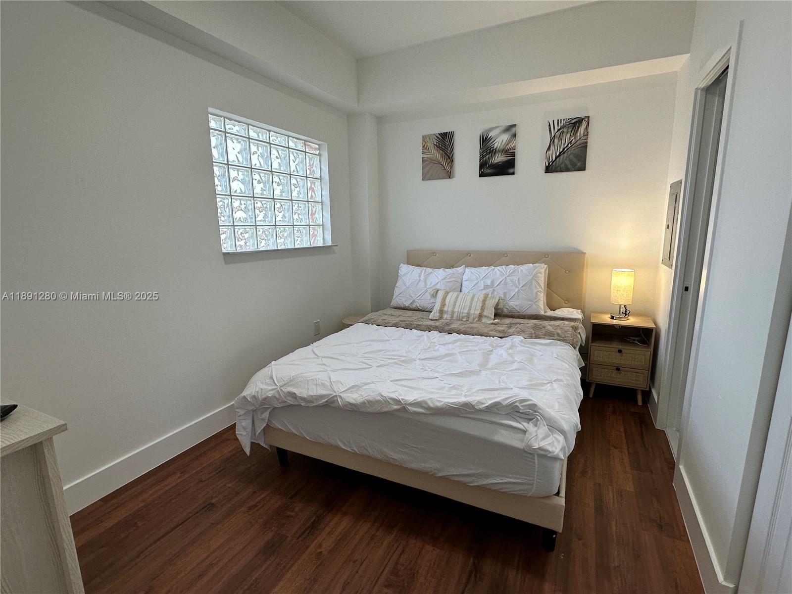 1638 Southwest 3rd Street, Unit 303 Miami, FL 33135 - Photo 12 of 17 a bedroom with a bed and wooden floor