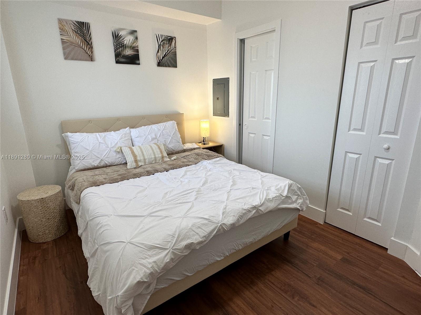 1638 Southwest 3rd Street, Unit 303 Miami, FL 33135 - Photo 13 of 17 a large bed sitting in a bedroom next to a wooden door