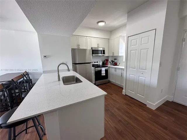 a kitchen with refrigerator and white stove