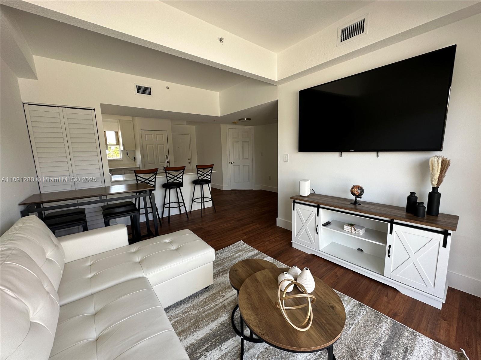 1638 Southwest 3rd Street, Unit 303 Miami, FL 33135 - Photo 4 of 17 a living room with furniture and a flat screen tv