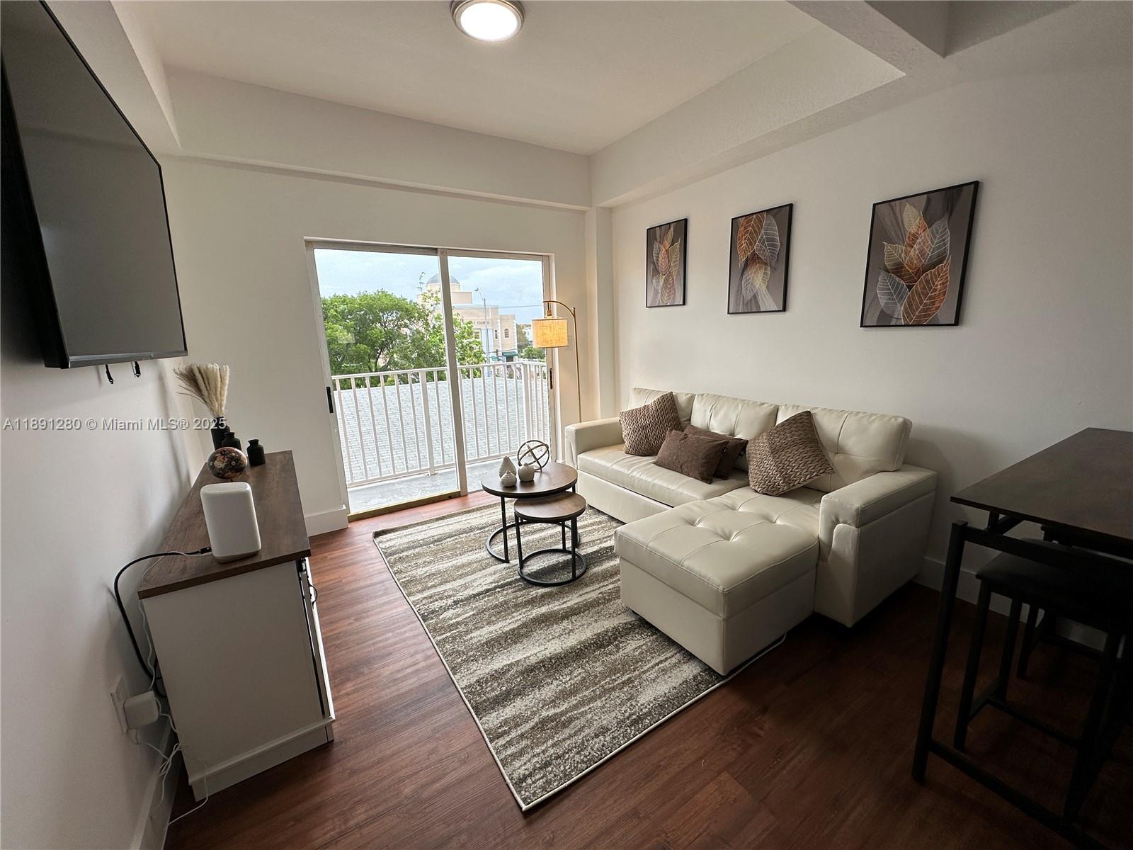1638 Southwest 3rd Street, Unit 303 Miami, FL 33135 - Photo 8 of 17 a living room with furniture and a flat screen tv