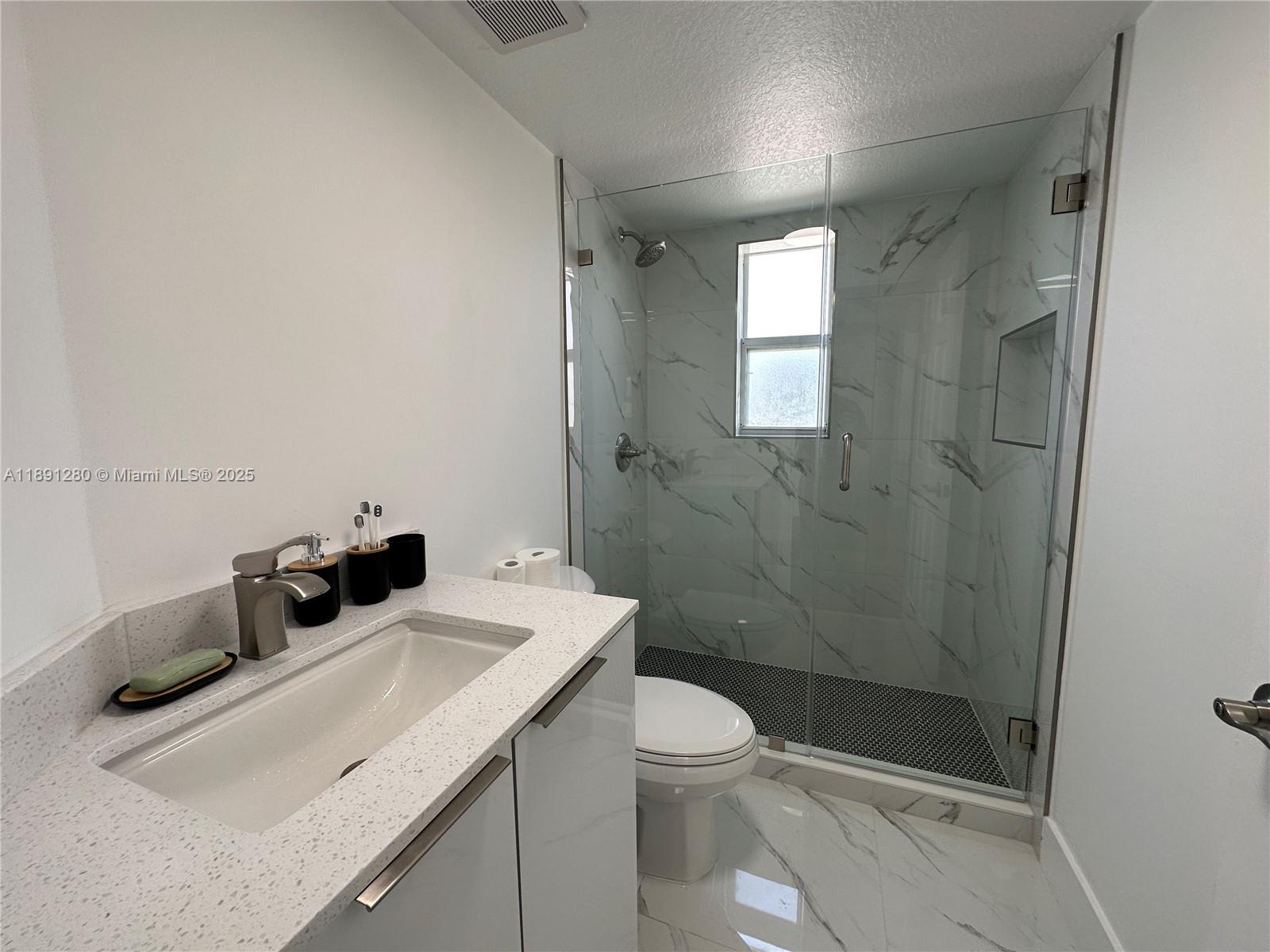 1638 Southwest 3rd Street, Unit 303 Miami, FL 33135 - Photo 9 of 17 a bathroom with a sink a toilet and shower
