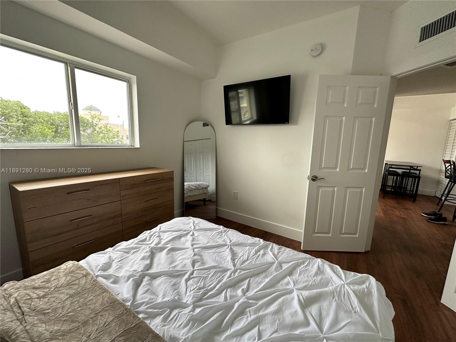 1638 Southwest 3rd Street, Unit 303 Miami, FL 33135 - Photo 10 of 17 a bedroom with a bed and a television