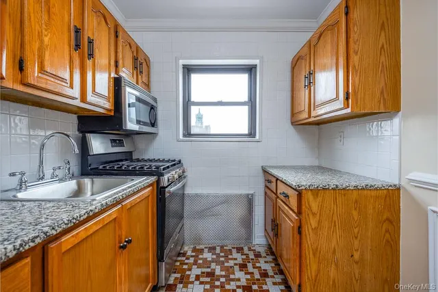 a kitchen with stainless steel appliances granite countertop a sink stove and cabinets
