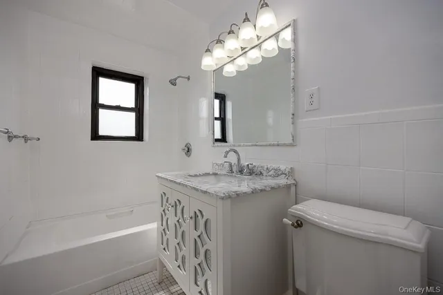 a bathroom with a granite countertop sink a toilet and shower