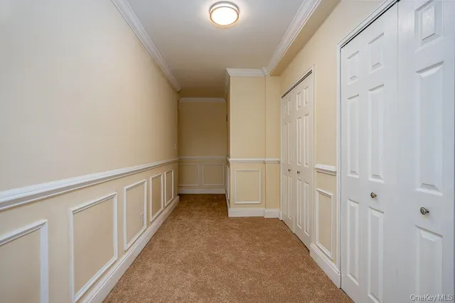 a view of a hallway with white walls and stairs