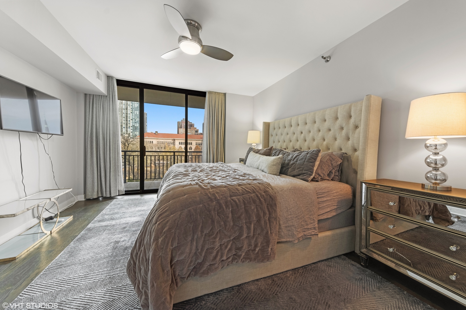 55 West Delaware Place, Unit 613 Chicago, IL 60610 - Photo 12 of 29 a spacious bedroom with a bed and a lamp on dresser