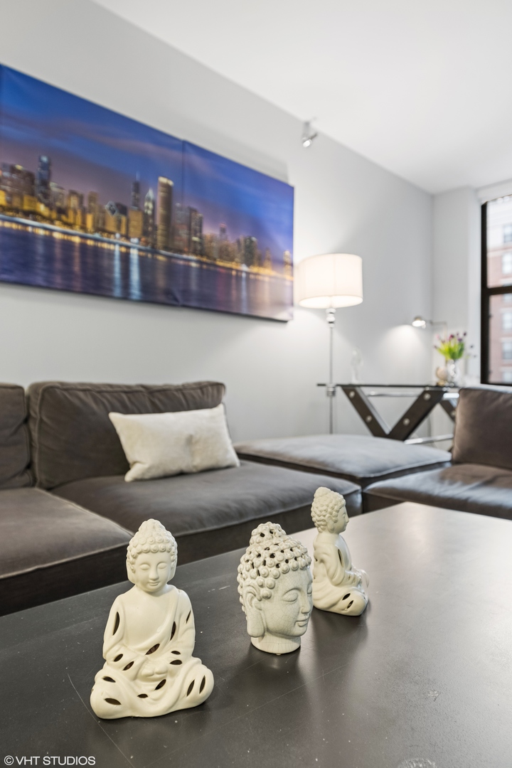 55 West Delaware Place, Unit 613 Chicago, IL 60610 - Photo 22 of 29 a living room with furniture and a lamp
