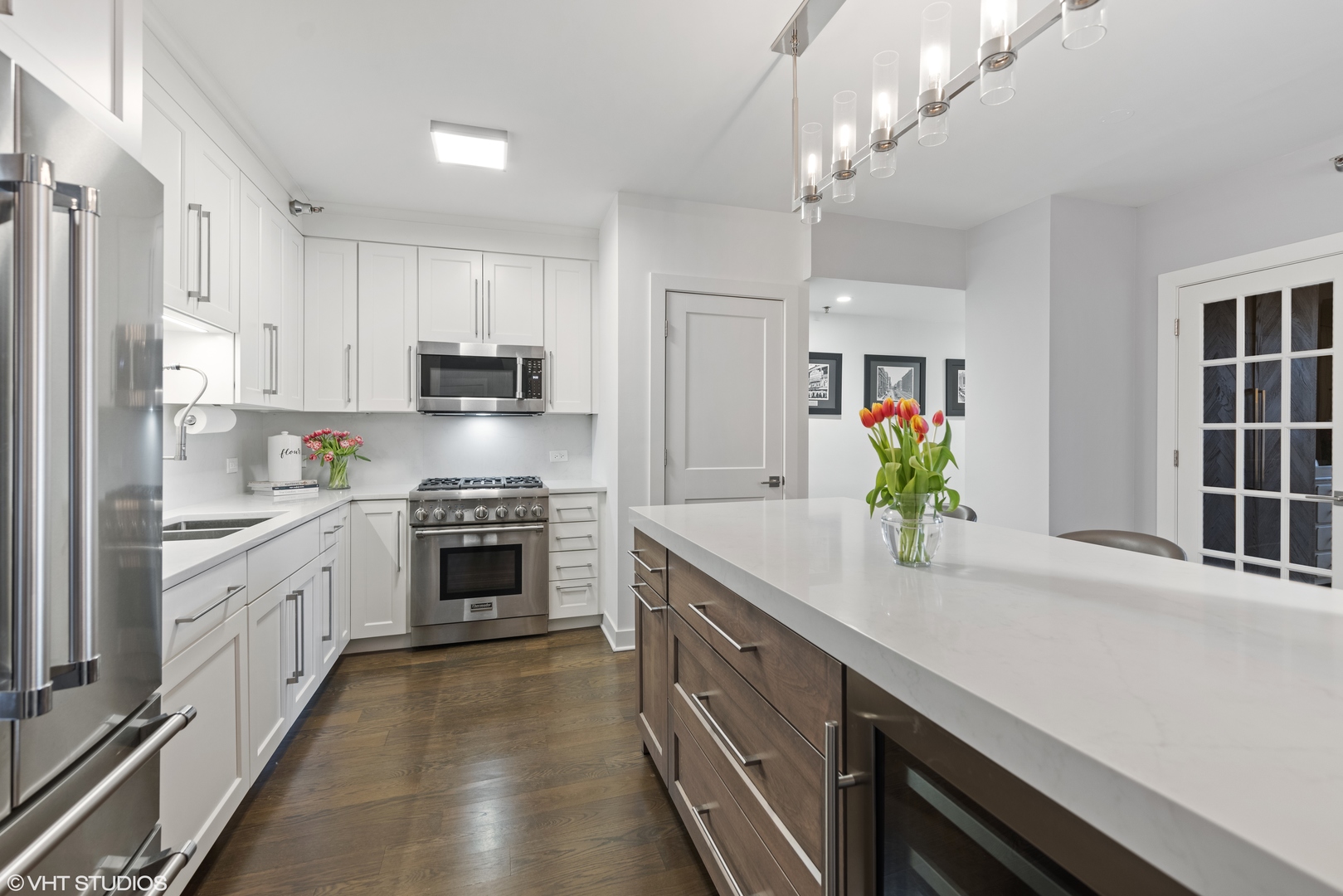 55 West Delaware Place, Unit 613 Chicago, IL 60610 - Photo 6 of 29 a kitchen with kitchen island granite countertop stainless steel appliances a stove a sink a refrigerator cabinets and a dining table