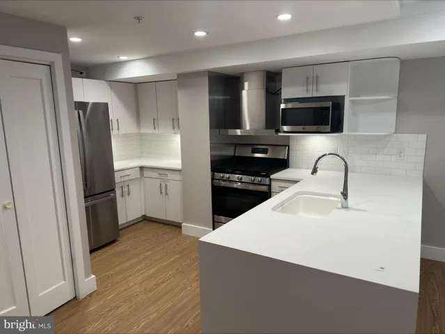 a kitchen with stainless steel appliances a refrigerator stove microwave and sink