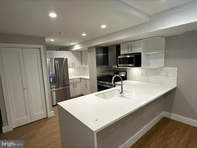 a kitchen with stainless steel appliances a refrigerator sink and microwave