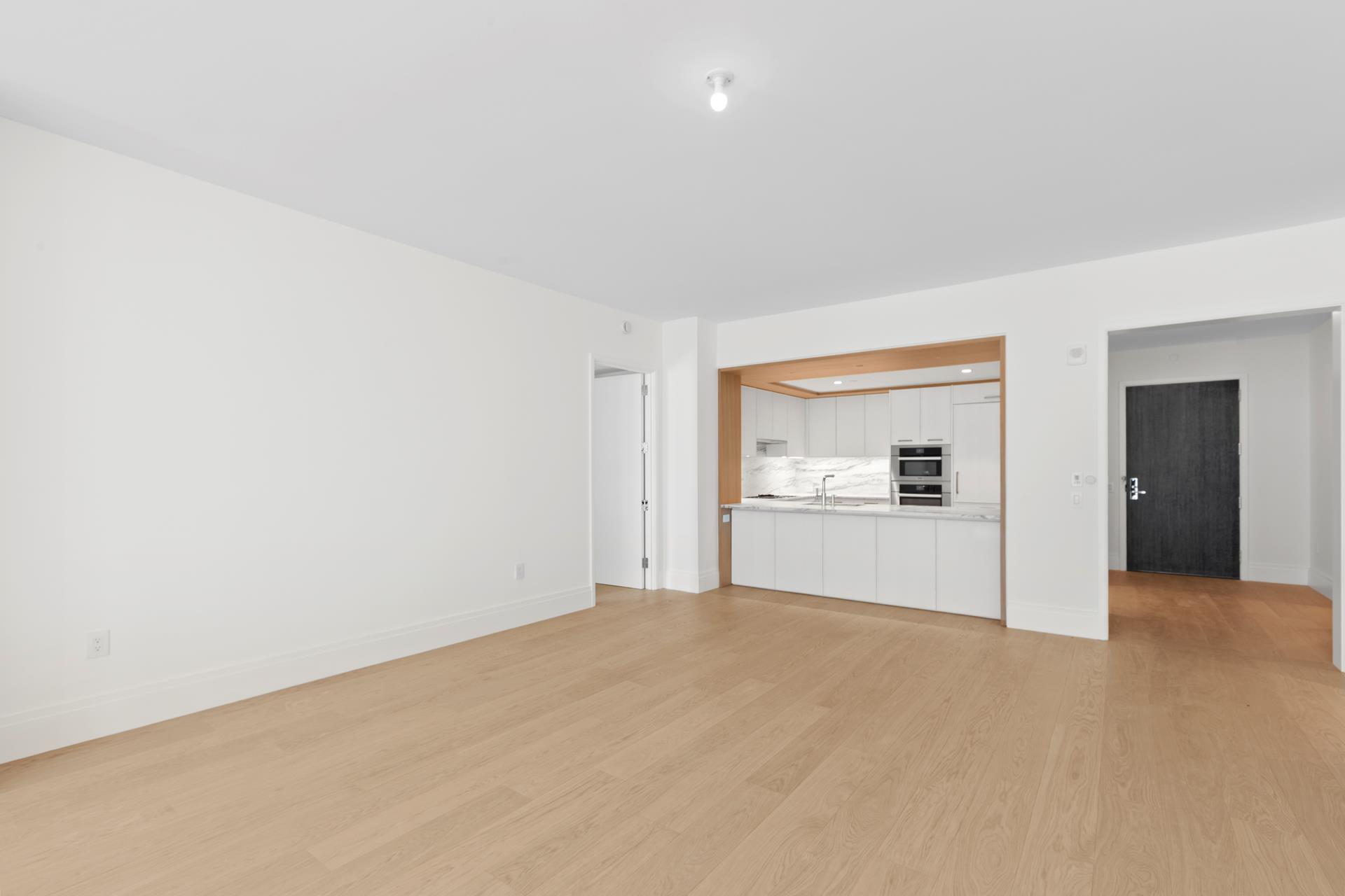 50 West 66th Street, Unit 15E Manhattan, NY 10023 - Photo 5 of 12 a view of a big room with wooden floor and a kitchen