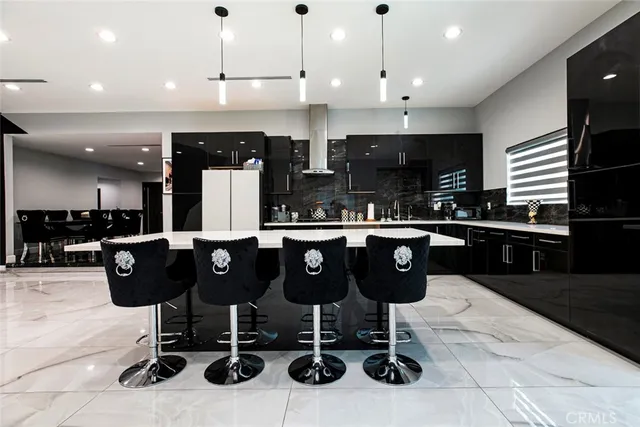 a large kitchen with a large counter top and stainless steel appliances