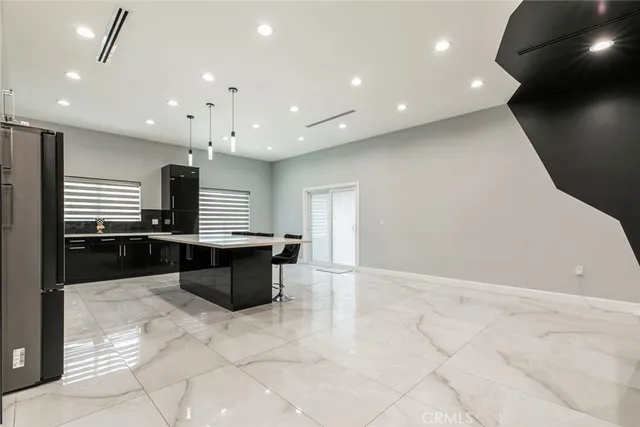 a large kitchen with a large counter top stainless steel appliances and cabinets