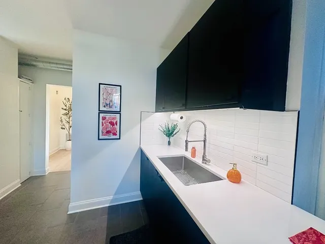 a view of kitchen island with stainless steel appliances wooden floor