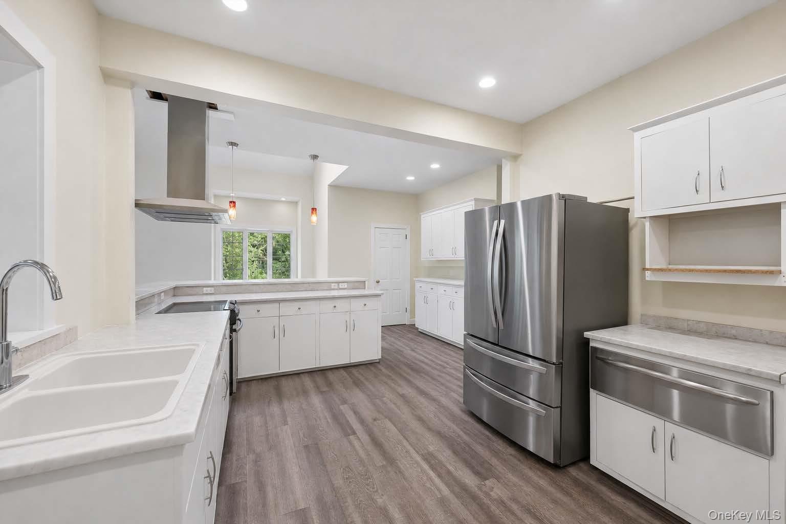 131 Red Creek Road Hampton Bays, NY 11946 - Photo 10 of 35 a kitchen with a refrigerator and a sink