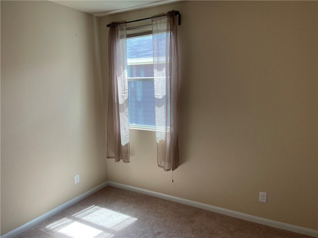 1420 Nevarez Kyle, TX 78640 - Photo 8 of 9 A well-lit room offers a comfortable atmosphere with soft carpeting and a clear window.