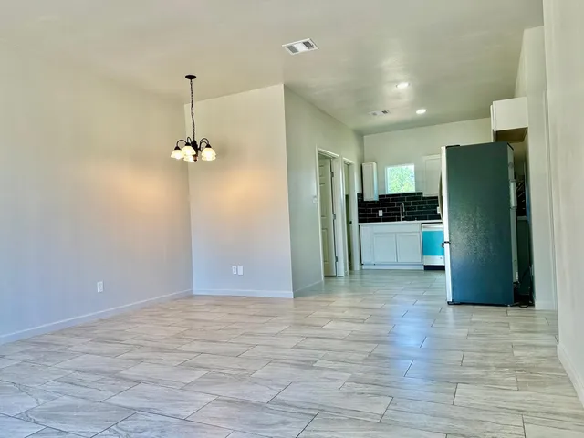 a view of a kitchen with a refrigerator a microwave and a sink