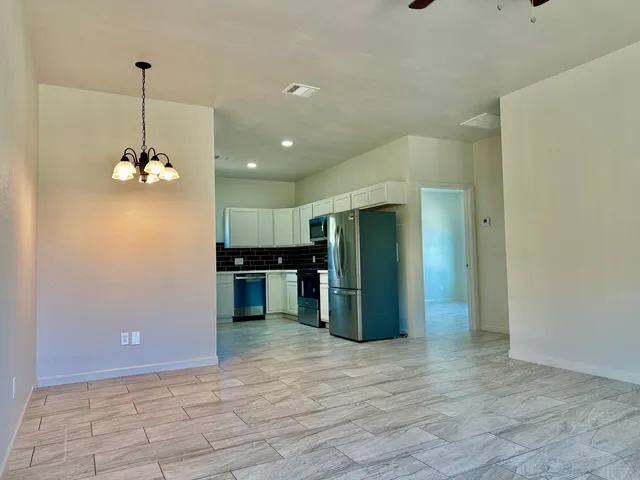 a view of a kitchen with a refrigerator and a kitchen counter top