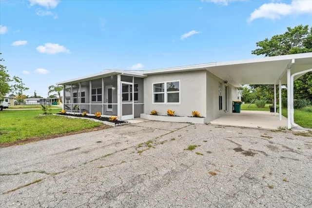 a view of a house with a yard and potted plants